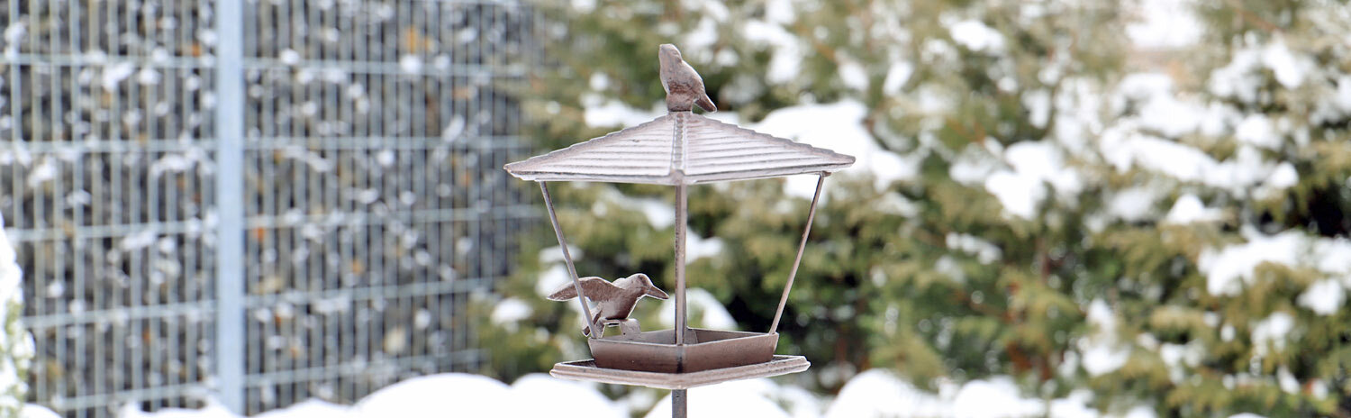 kleines Vogelfutterhaus VFH1 auf Stab in Winterlandschaft