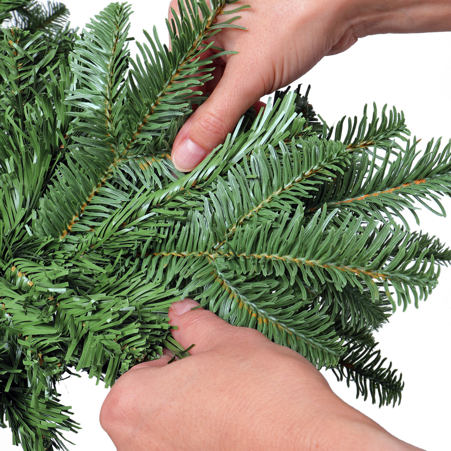 das Foto zeigt Hände, welche die Zweige des Künstlichen Weihnachtsbaums ausrichten und in Form zupfen
