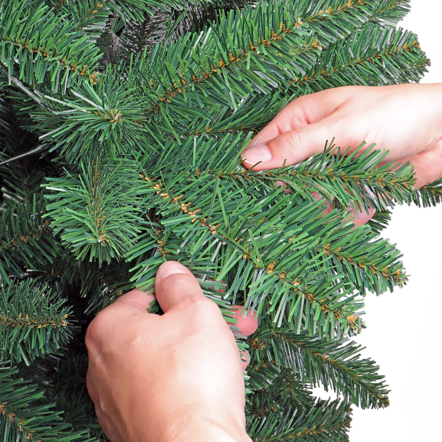 das Foto zeigt Hände, welche die Zweige des Künstlichen Weihnachtsbaums ausrichten und in Form zupfen